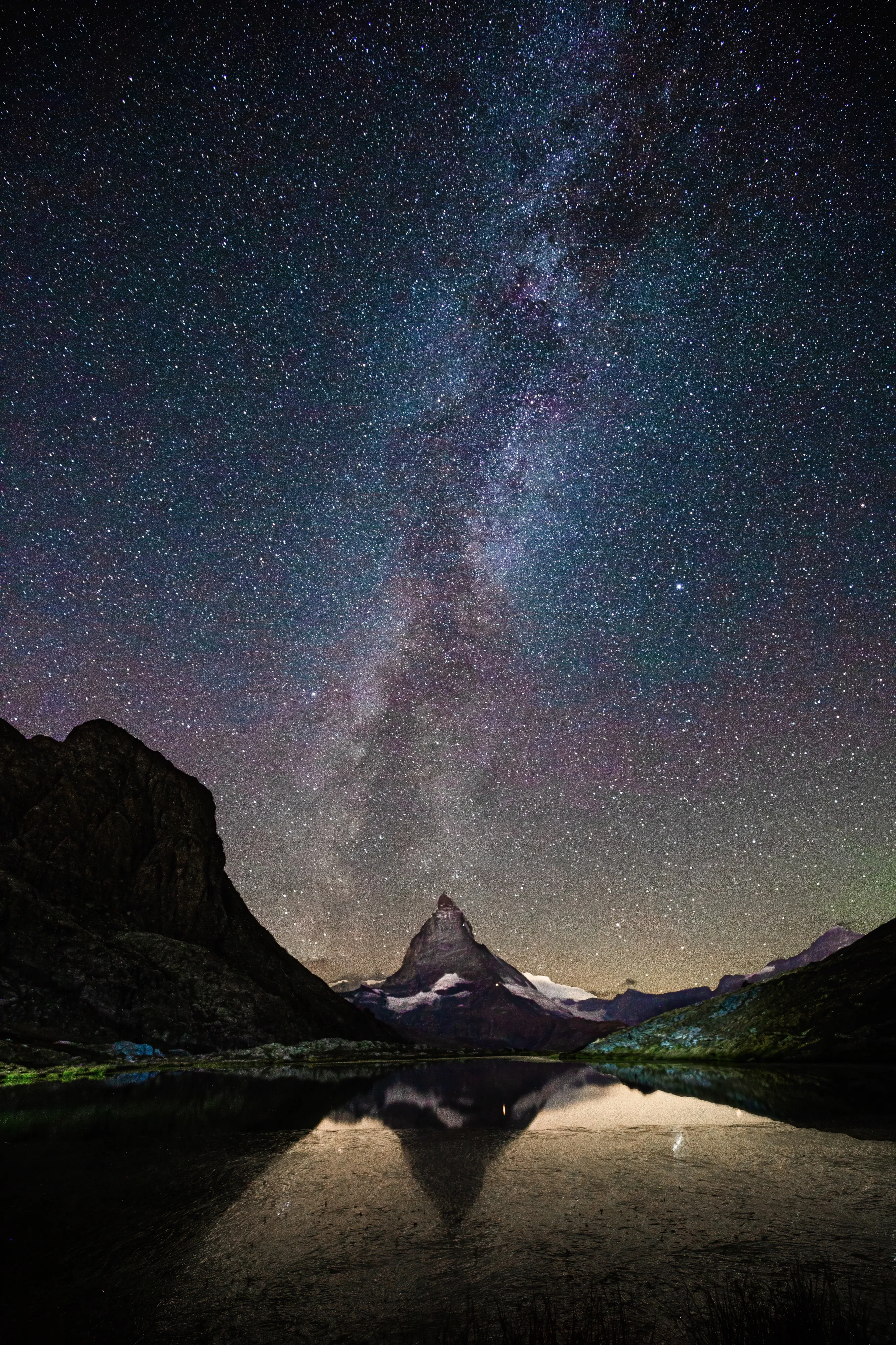 The Milky Way rising above the Matterhorn, reflected in a mountain lake